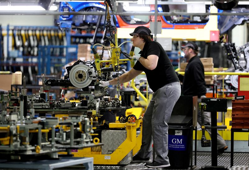 FILE PHOTO: A worker uses a hoist to move components along the production line for the Qashqai model car at the Nissan car factory in Sunderland, Britain, December 16, 2025. REUTERS/Phil Noble/File Photo