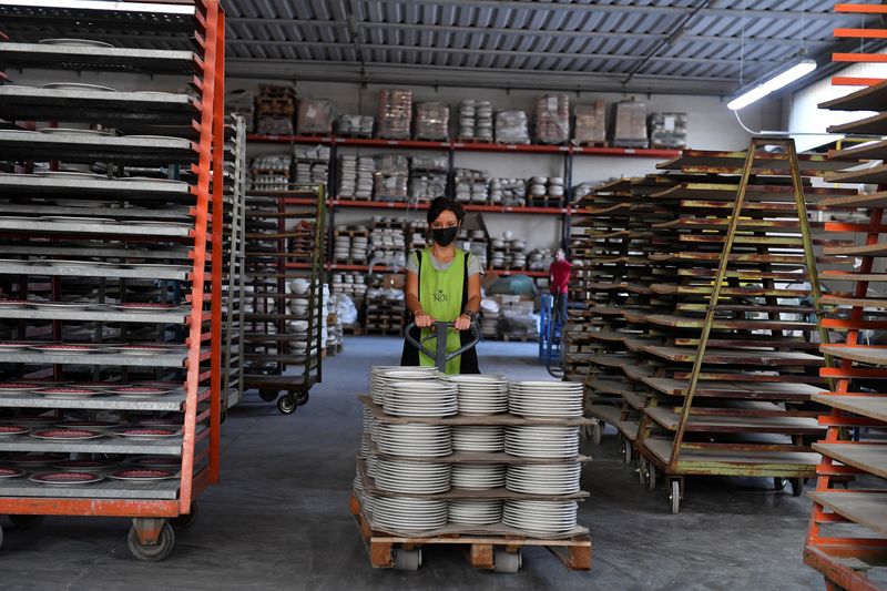 An employee works at a ceramics factory where the workers start their shifts before dawn to optimise sunlight and save energy, in Citta di Castello, Italy, August 30, 2022. REUTERS/Jennifer Lorenzini