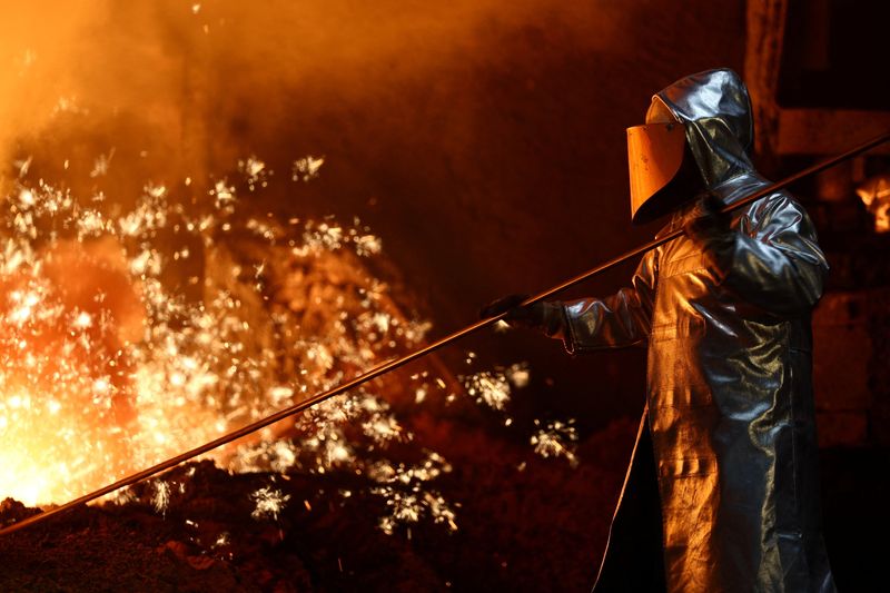 A steel worker stands amid sparks of raw iron coming from a blast furnace at a ThyssenKrupp steel factory in Duisburg, Germany, November 5, 2025. REUTERS/Leon Kuegeler
