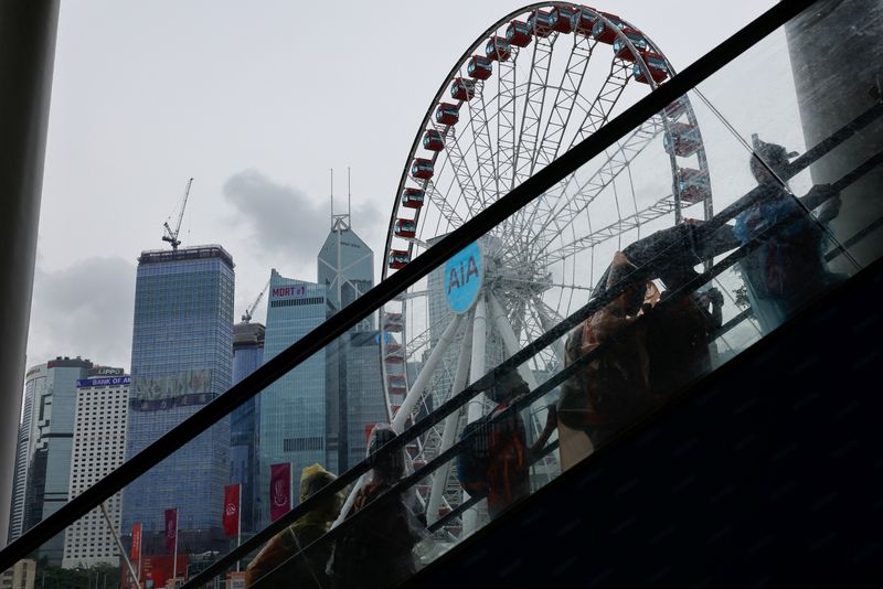 Chinese tourists walk in front of Central financial district, in Hong Kong, China, August 11, 2023. REUTERS/Tyrone Siu