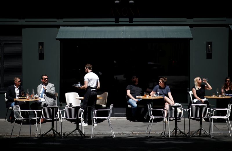 A waiter serves customers on a terrace of a restaurant in Paris, France, June 2, 2020. REUTERS/Benoit Tessier