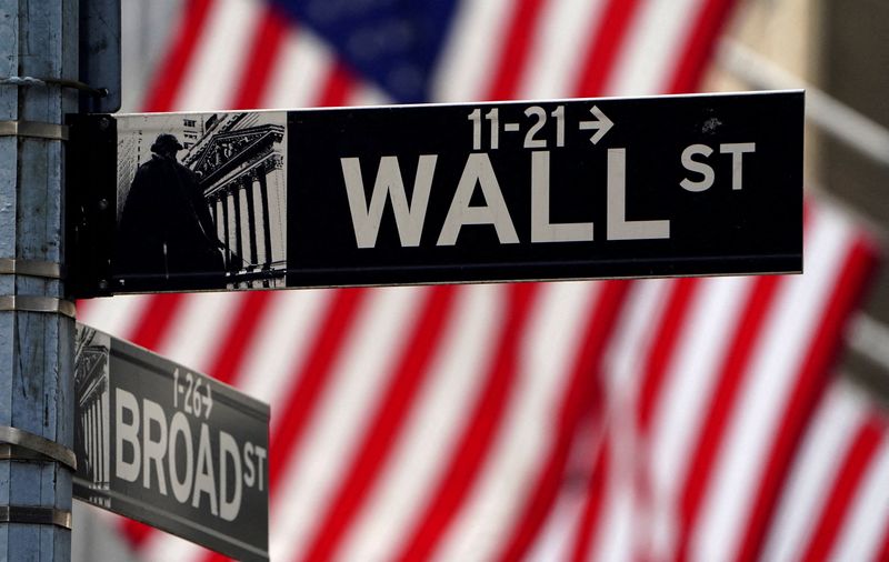 FILE PHOTO: A Wall Street sign is pictured outside the New York Stock Exchange amid the coronavirus disease (COVID-19) pandemic in the Manhattan borough of New York City, New York, U.S., April 16, 2021. REUTERS/Carlo Allegri/File Photo