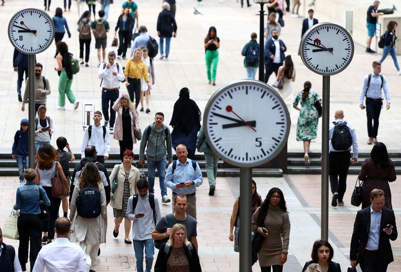 FILE PHOTO: Workers walk through the Canary Wharf financial district, in London, Britain, August 3, 2023. REUTERS/Toby Melville/File Photo