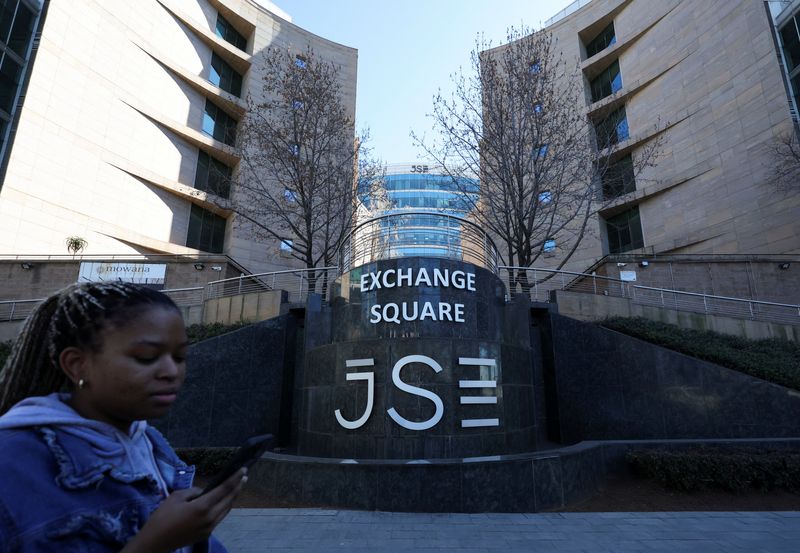 FILE PHOTO: A woman walks at the Johannesburg Stock Exchange (JSE), in Sandton, South Africa, August 1, 2025. REUTERS/Siphiwe Sibeko/File Photo