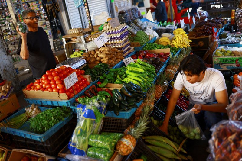 A worker sells fruits and vegetables at a market following March's inflation surge driven by rising food and energy prices, in Ciudad Juarez, Mexico, April 15, 2026. REUTERS/Jose Luis Gonzalez