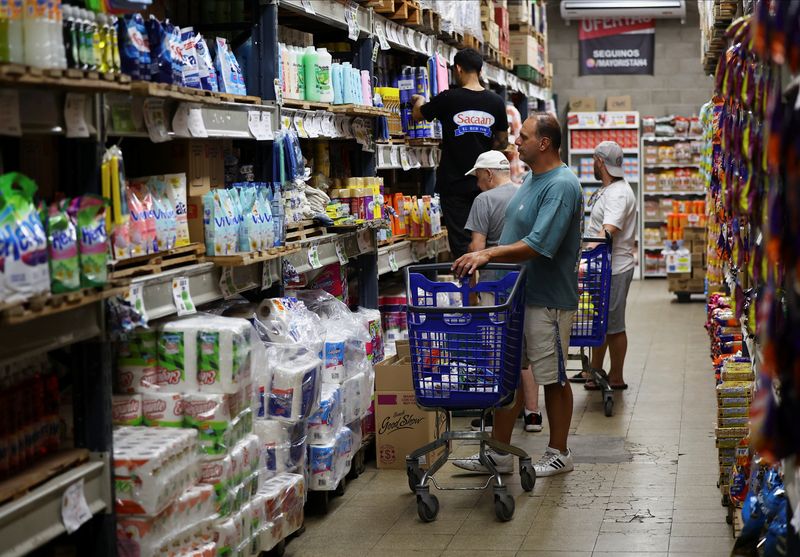 A shopper checks prices at a supermarket, in Villa Martelli on the outskirts of Buenos Aires, Argentina January 13, 2026. REUTERS/Agustin Marcarian