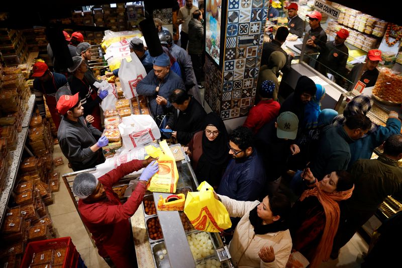 Kashmiri people buy bakery items and sweets at a shop ahead of the Eid al-Fitr, which marks the end of the Muslim fasting month of Ramadan, at a market area in Srinagar, Indian Kashmir, March 18, 2026.REUTERS/Sharafat Ali