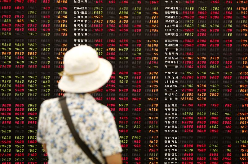 An investor looks at an electronic board showing stock price index at a stock brokerage firm in Seoul July 1, 2009. Frustrated by poor returns and high fees, South Korean retail investors are dumping equity funds and picking stocks on their own, raising the prospect of consolidation in the domestic asset management industry. Picture taken July 1, 2009. To match analysis INVESTORS/KOREA. REUTERS/Jo Yong-Hak (SOUTH KOREA BUSINESS)