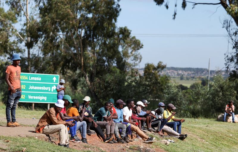 Job seekers wait beside a road for casual work offered by passing motorists in Eikenhof, south of Johannesburg, South Africa, February 26, 2025. REUTERS/Siphiwe Sibeko