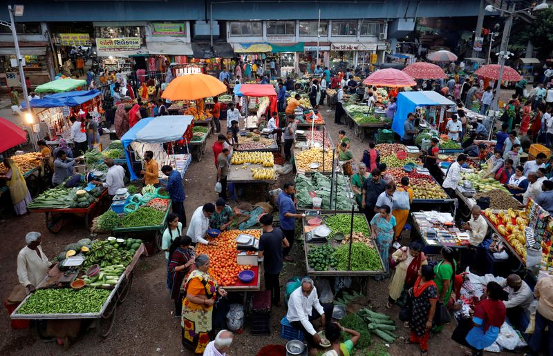 Customers buy fruits and vegetables at an open air evening market in Ahmedabad, India, August 21, 2023. REUTERS/Amit Dave