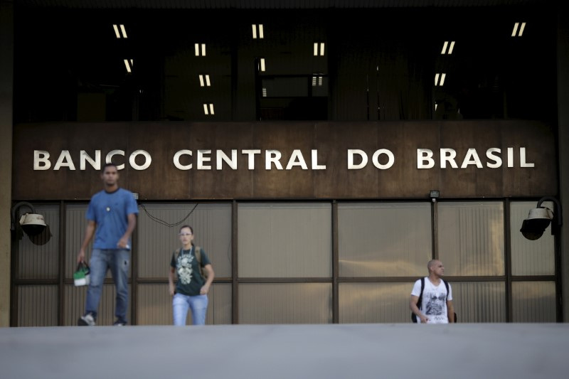 People walk out of the headquarters of the central bank in Brasilia, Brazil, September 23, 2015. The Brazilian real tumbled on Wednesday as the central bank's increased intervention in the currency market failed to offset fears of deteriorating government finances, a mounting political crisis and weaker Chinese demand for raw materials. REUTERS/Ueslei Marcelino