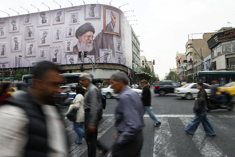 People walk near a billboard with an image of the late Iranian Supreme Leader Ayatollah Ali Khamenei, in Tehran, Iran, May 19, 2026. Majid Asgaripour/WANA (West Asia News Agency) via REUTERS