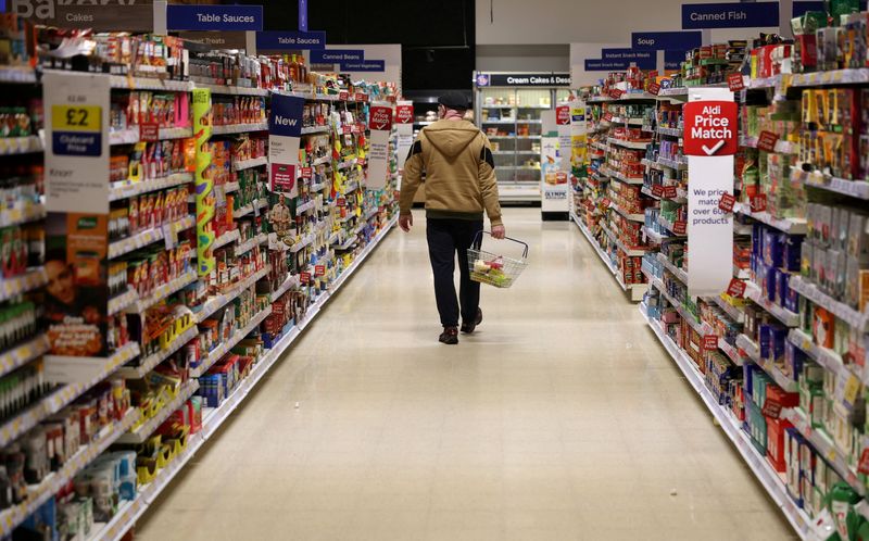 FILE PHOTO: A shopper walks along an aisle inside a Tesco supermarket in Manchester, Britain, February 5, 2026 REUTERS/Phil Noble/File Photo