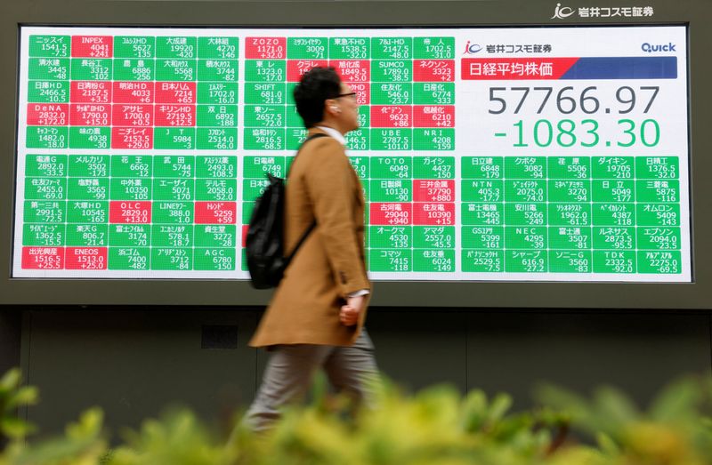 A man walks in front of a stock quotation board displaying the Nikkei share average outside a brokerage in Tokyo, Japan, March 2, 2026. REUTERS/Manami Yamada