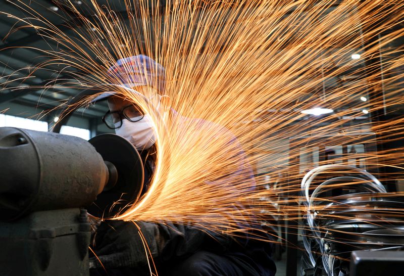 FILE PHOTO: A worker wearing a face mask works on a production line manufacturing bicycle steel rim at a factory, as the country is hit by the novel coronavirus outbreak, in Hangzhou, Zhejiang province, China March 2, 2020. China Daily via REUTERS/File Photo