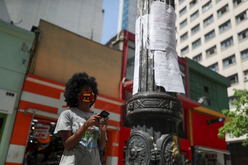 A woman looks at job listings posted on a light pole in downtown Sao Paulo, Brazil, September 30, 2020. REUTERS/Amanda Perobelli