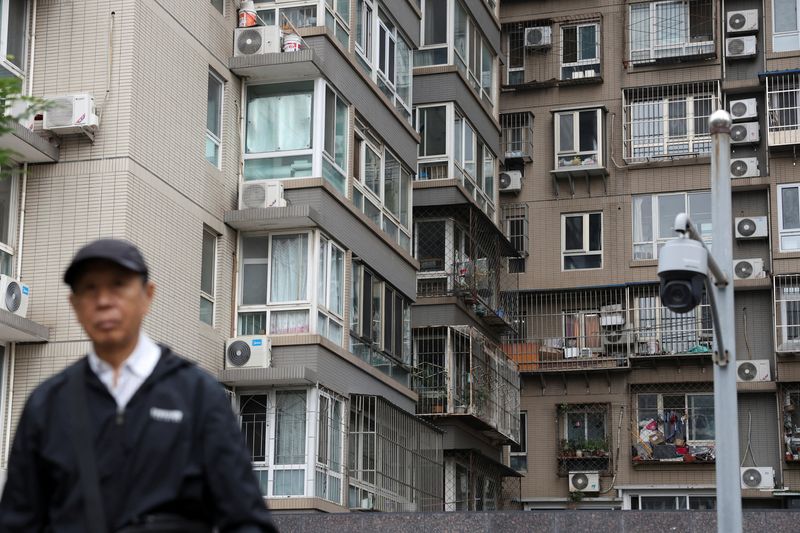 A man walks by a surveillance camera near residential buildings in Beijing, China October 17, 2024. REUTERS/Florence Lo