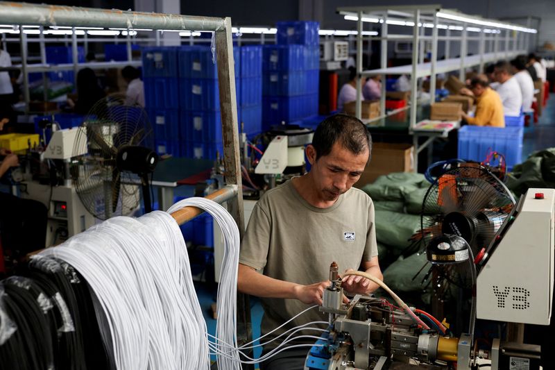 FILE PHOTO: An employee works on USB cables production at a plastic accessories factory in Dongguan, Guangdong province, China, April 2, 2026.  REUTERS/Go Nakamura/File Photo