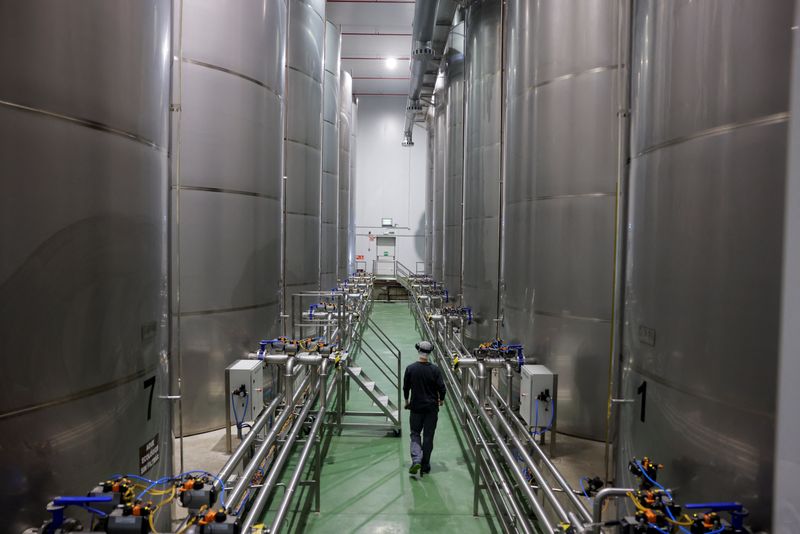 A worker walks between tanks filled with olive oil at the Spanish olive oil producer Dcoop's factory in Antequera, Spain, April 9, 2025. REUTERS/Jon Nazca