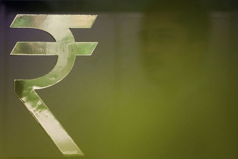 FILE PHOTO: A man walks past a Rupee installation at the Reserve Bank Of India (RBI) headquarters in Mumbai, India, April 8, 2026. REUTERS/Francis Mascarenhas/File Photo