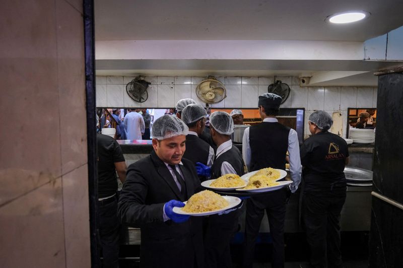 FILE PHOTO: A waiter carries biryani to serve customers inside Arsalan restaurant in Kolkata, India, March 13, 2026. REUTERS/Sahiba Chawdhary/File Photo