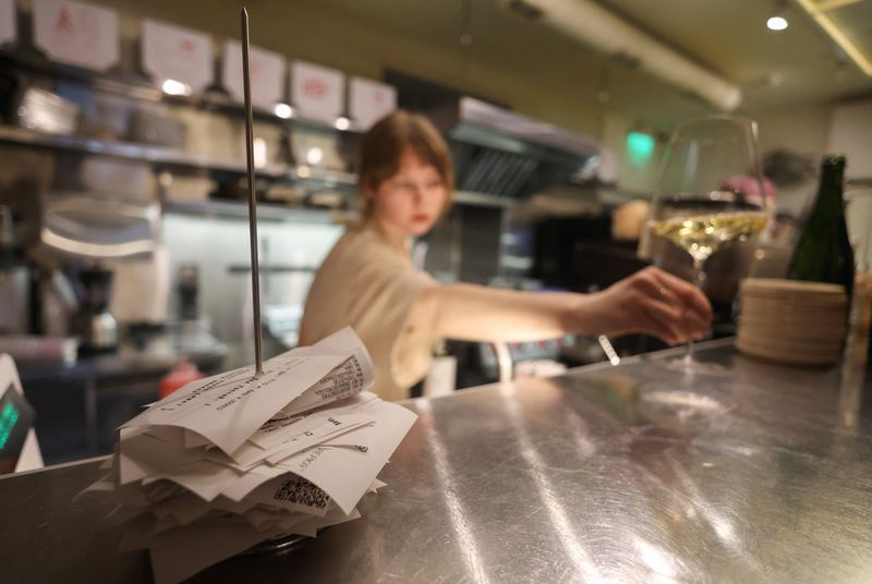 A waitress holds a glass of wine in the Skrepka restaurant in Moscow, Russia, April 17, 2026. REUTERS/Ramil Sitdikov