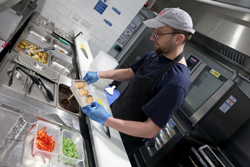 Team member Bartosz prepares a meal for takeaway at a K10 Japanese restaurant in London, Britain, January 16, 2026. REUTERS/Toby Melville