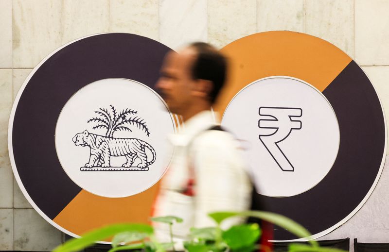 A man walks past a logo of the Reserve Bank of India (RBI) and the Indian Rupee inside the RBI headquarters in Mumbai, India, December 6, 2024. REUTERS/Francis Mascarenhas