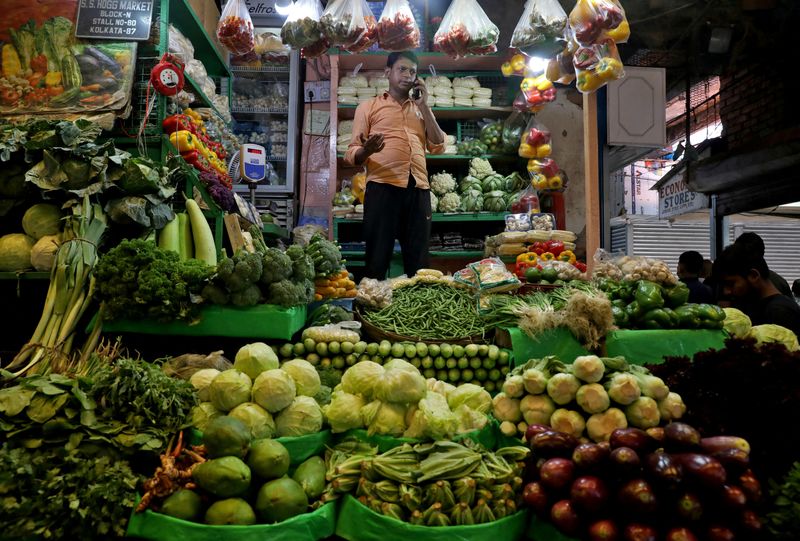 FILE PHOTO: Debashis Dhara, a vegetable vendor, speaks on his mobile phone at a retail market area in Kolkata, India, March 22, 2022. REUTERS/Rupak De Chowdhuri/File Photo