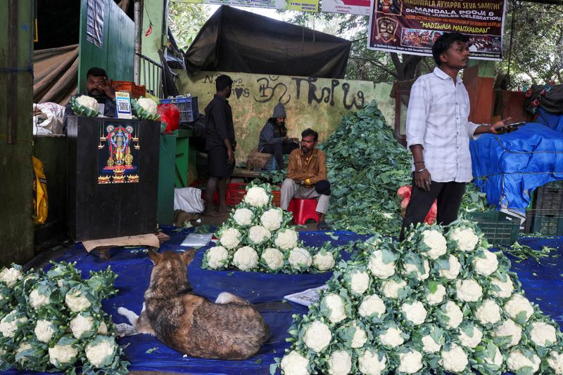 FILE PHOTO: Vendors sit at a vegetable stall selling cauliflowers at a market in Bengaluru, India, January 12, 2026. REUTERS/Priyanshu Singh/File Photo