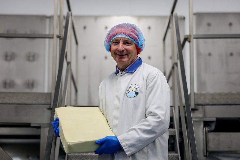 Michael Harte, managing director of Bridge Cheese, holds a block of cheese at the Bridge Cheese factory in Telford, Britain, June 10, 2026. REUTERS/Temilade Adelaja