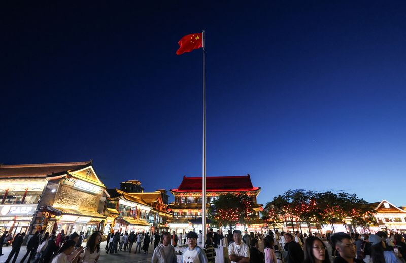 A Chinese national flag flies in the wind as people walk in the Dazhao Square in Hohhot, Inner Mongolia autonomous region, China, June 10, 2026. REUTERS/Maxim Shemetov