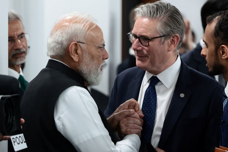British Prime Minister Keir Starmer speaks with India's Prime Minister Narendra Modi as they arrive for a working session with G7 leaders and outreach partners on promoting economic growth during the G7 Summit in Evian-les-Bains, France, June 17, 2026. REUTERS/Evelyn Hockstein