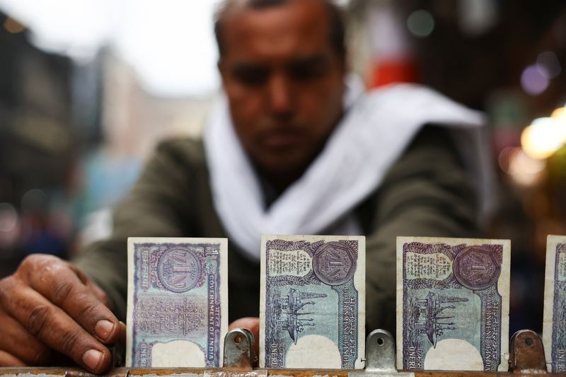 A man arranges notes of one rupee of Indian currency at a roadside currency exchange stall in the old quarters of Delhi, India, February 2, 2026. REUTERS/Anushree Fadnavis
