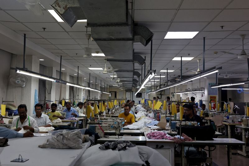 Garment workers stitch clothes at a textile factory in Noida, India, July 31, 2025. REUTERS/ Bhawika Chhabra