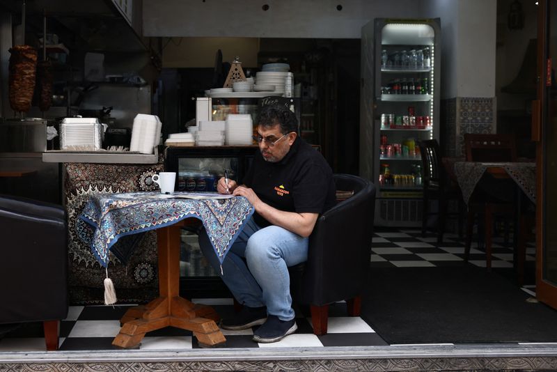A man amends a menu at a restaurant in Tower Hamlets, London, Britain, May 3, 2026. REUTERS/Jack Taylor