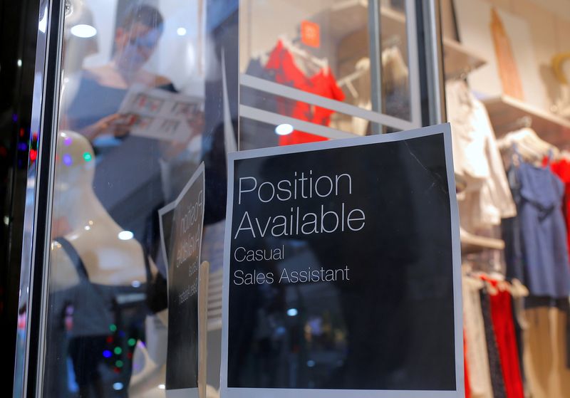 A sales assistant is seen through the window of a retail store displaying a job vacancy sign in central Sydney, Australia, December 5, 2016.  REUTERS/Steven Saphore