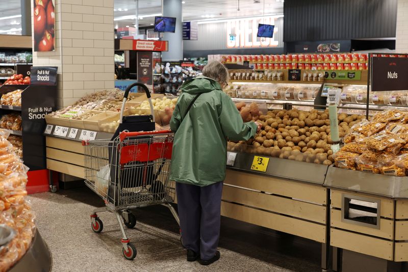 A shopper selects potatoes in the fruit and vegetable section of a Coles supermarket in Bondi Junction, in Sydney, Australia, October 29, 2025. REUTERS/Hollie Adams