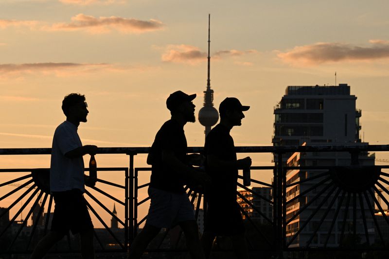 People walk across the Oberbaum bridge at sunset, with the television tower in the background in Berlin, Germany, August 17, 2025.  REUTERS/Annegret Hilse