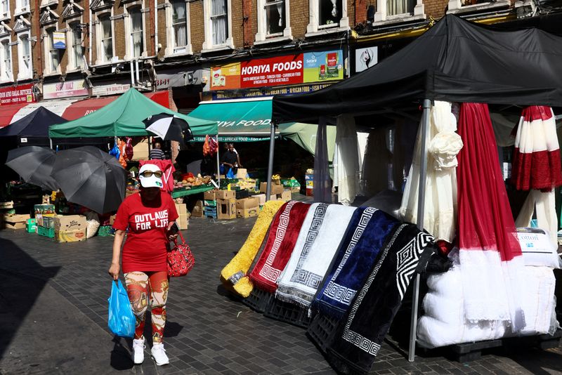 FILE PHOTO: A woman carries her shopping through Brixton market in London, Britain, May 26, 2026. REUTERS/Jack Taylor/File Photo