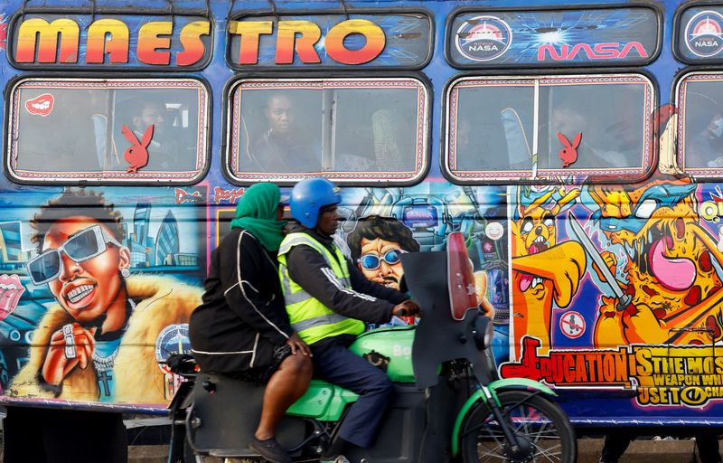FILE PHOTO: A motorcycle taxi carries a woman passenger as they ride past a commuter bus during a strike by public transport operators driven by rising fuel costs, linked to global supply pressures following the U.S.-Israeli conflict with Iran, in Nairobi, Kenya May 19, 2026. REUTERS/Thomas Mukoya/File Photo