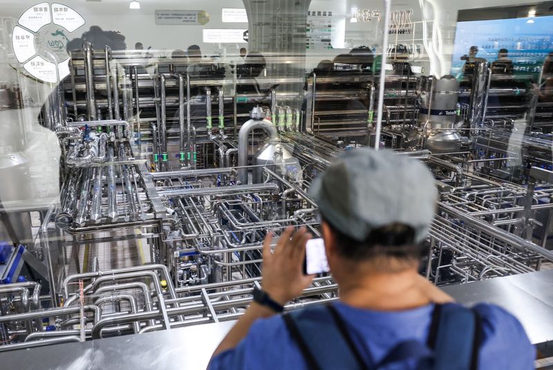 A journalist films a processing area at Mengniu milk processing factory during organized media tour in Hohhot, Inner Mongolia Autonomous Region, China, June 11, 2026. REUTERS/Maxim Shemetov