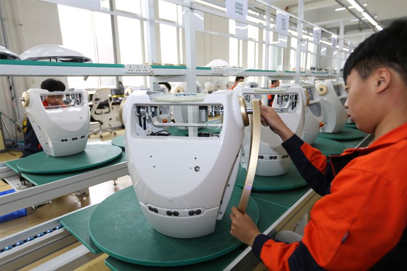 Workers assemble robots at the production line of Chuangze Intelligent Robot in Rizhao, Shandong province, China April 29, 2019. REUTERS/Stringer