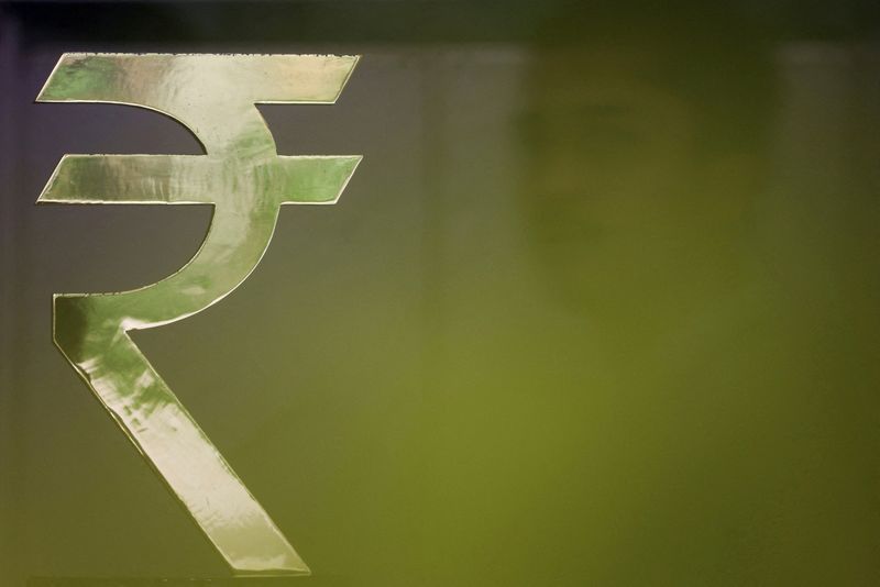 FILE PHOTO: A man walks past a Rupee installation at the Reserve Bank Of India (RBI) headquarters in Mumbai, India, April 8, 2026. REUTERS/Francis Mascarenhas/File Photo