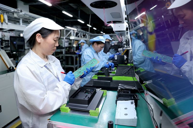 Workers work on a production line manufacturing smart automotive central control navigation products at a factory of Beidou Intelligent Connected Vehicle Technology Co. (BICV) in the High Tech Industrial Development Zone in Suqian, Jiangsu Province, China April 9, 2025. China Daily via REUTERS