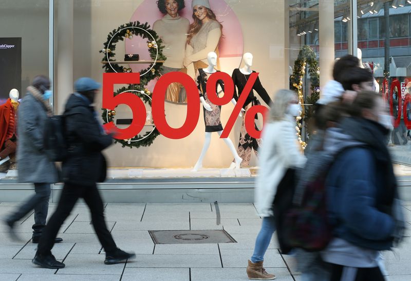 Shoppers walk past a discount sign, in Frankfurt, Germany December 14, 2020. REUTERS/Ralph Orlowski
