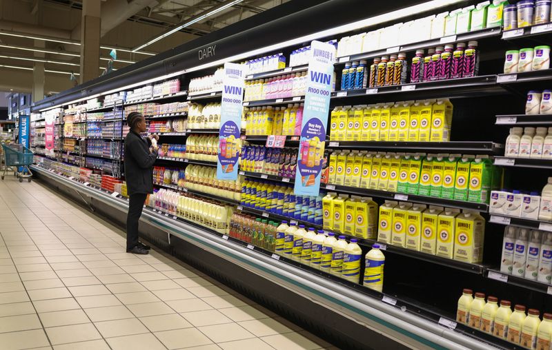 FILE PHOTO: A shopper looks for items at the dairy section as she shops at a Checkers outlet in Johannesburg, South Africa, May 20, 2025. REUTERS/Siphiwe Sibeko/File Photo