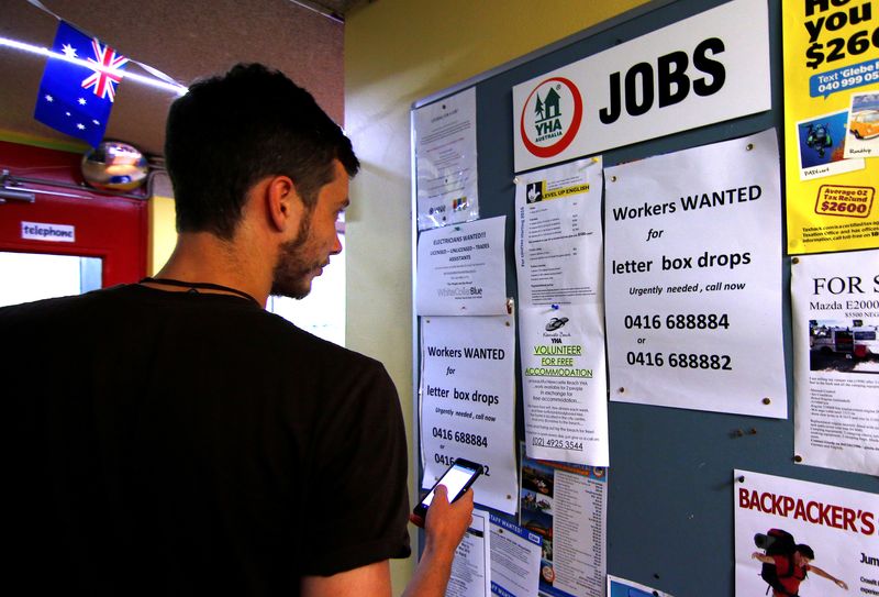 A man uses his phone to record a job add posted on a notice board at a backpacker hostel in Sydney, Australia, May 9, 2016. Picture taken May 9, 2016.  REUTERS/Steven Saphore