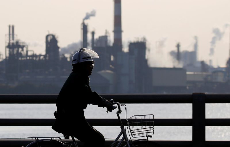 FILE PHOTO: A worker cycles near a factory at the Keihin industrial zone in Kawasaki, Japan, November 15, 2017.  REUTERS/Toru Hanai/ File Photo