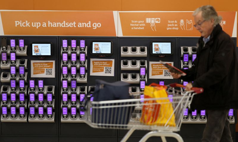 FILE PHOTO: A customer walks past scan and pack handsets inside a Sainsbury's supermarket in Cobham, Britain, October 2, 2024. REUTERS/Mina Kim/File Photo